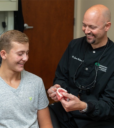 Dentist showing teen boy how athletic moutghuards work