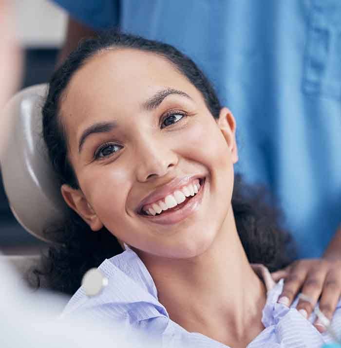 A smiling woman seeing her dentist for gum disease treatment