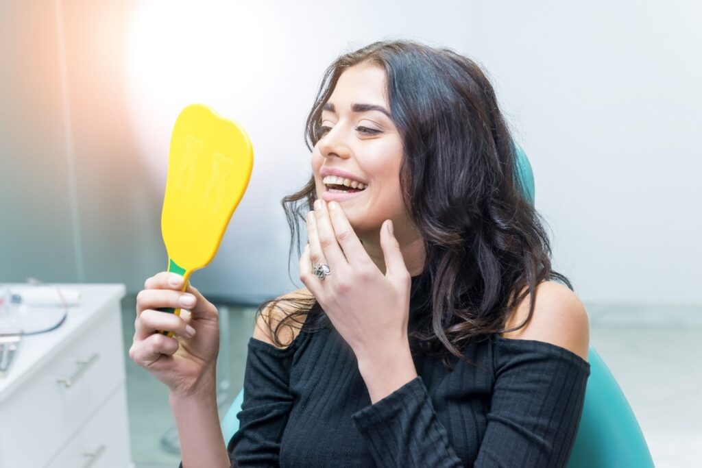 Woman smiling at reflection in yellow mirror